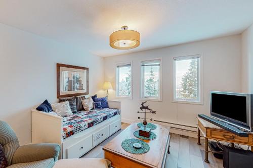 ビッグ・ホワイトにあるSnowCrest Village, Unit 5Bのベッドとテレビのあるリビングルーム