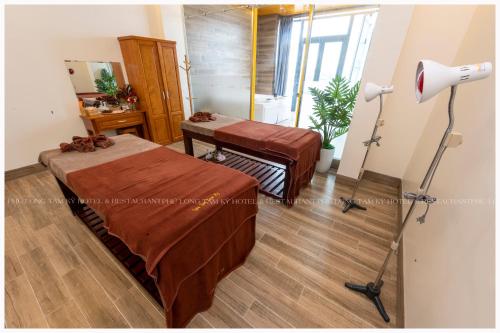 a hotel room with two beds and a lamp at Phú Long Tam Kỳ Hotel & Restaurant in Tam Ky