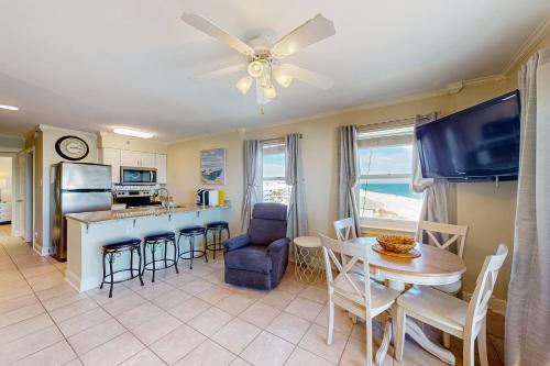 a kitchen and living room with a table and a tv at Tradewinds 501 in Orange Beach