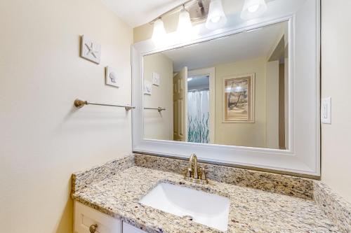 a bathroom with a sink and a mirror at Tradewinds 501 in Orange Beach