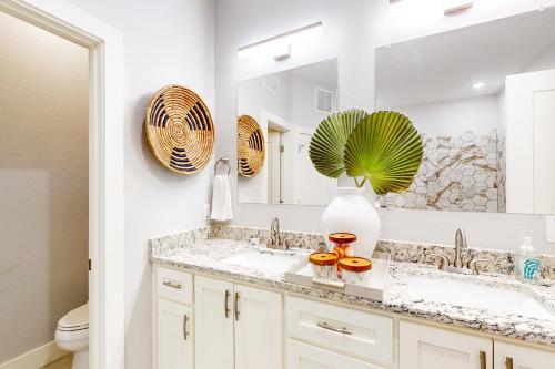 La salle de bains est pourvue de 2 lavabos et d'un miroir. dans l'établissement The Driftwood Sanctuary, à Galveston