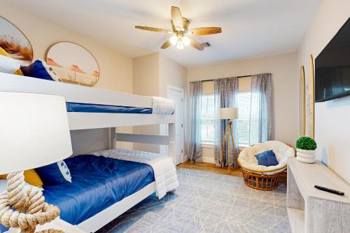 a bedroom with two bunk beds and a chair at The Driftwood Sanctuary in Galveston