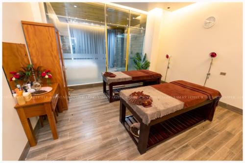 a living room with two tables and a mirror at Phú Long Tam Kỳ Hotel & Restaurant in Tam Ky
