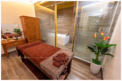 a bathroom with a shower and a bench and a plant at Phú Long Tam Kỳ Hotel & Restaurant in Tam Ky