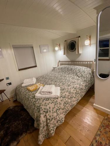 a bedroom with a bed with two towels on it at Muffins Meadow Shepherds Hut in Tillingham