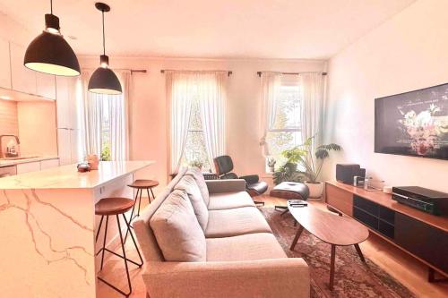 a living room with a couch and a bar in it at Airy, modern Penthouse in a Brooklyn Brownstone in Brooklyn