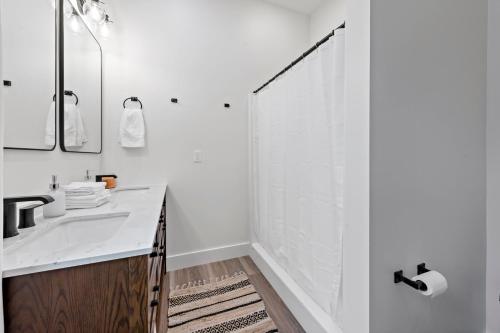 a white bathroom with a sink and a shower at Riverview in Port Clinton - Apt A 