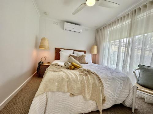 - une chambre avec un lit blanc et une fenêtre dans l'établissement Boho Beach House, à Rosebud