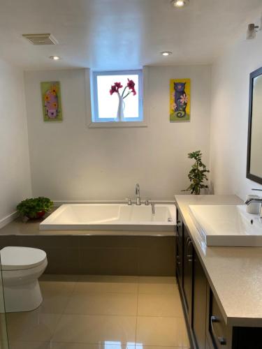 łazienka z wanną, toaletą i umywalką w obiekcie Beautiful private full condo w mieście Brossard