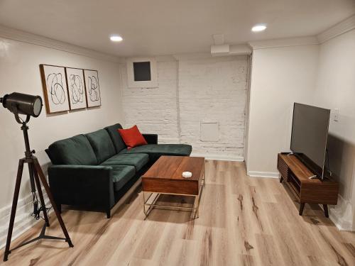 a living room with a green couch and a television at 2-Bedroom in the Heart of Denver in Denver