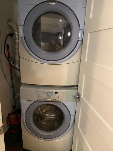 a washing machine with a mirror on top of it at Beautiful private full condo in Brossard