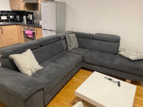 a living room with a gray couch and a table at Eaglet 2 Bedroom Luxury Home near Etihad Staduim in Manchester