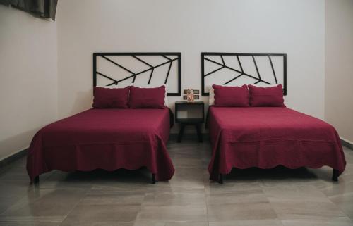 - 2 lits avec des couvertures rouges dans une chambre dans l'établissement MCI HOTEL, à San Juan de los Lagos