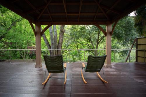two green chairs sitting on top of a porch at glampark Shikisou Shimane in Izumo