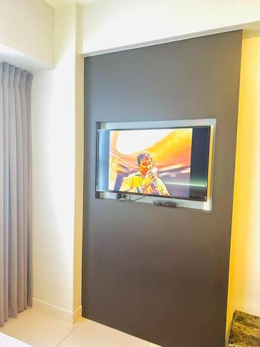 a television on a wall in a room at 41st Floor Horizons 101 Condo in Cebu City