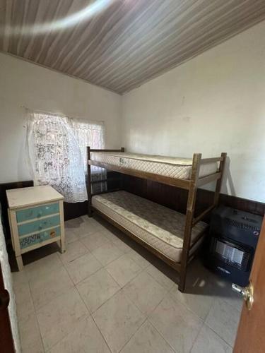 Cette petite chambre comprend des lits superposés et une table. dans l'établissement Lo de Sonia, à Costa Azul