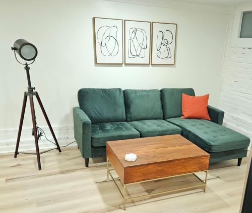 2-Bedroom in the Heart of Denver في دنفر: غرفة معيشة مع أريكة خضراء وطاولة قهوة