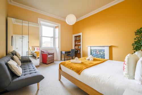 a bedroom with a large bed and a couch at 5-BR 3-BTH Newington Apartment - Modern & Spacious in Edinburgh