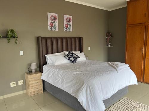 a bedroom with a large bed and two pictures on the wall at Precious Estates Pearls in Zeerust
