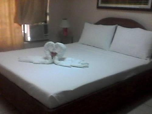 a bed with two white towels on top of it at Adtempco bed and breakfast in Bangued