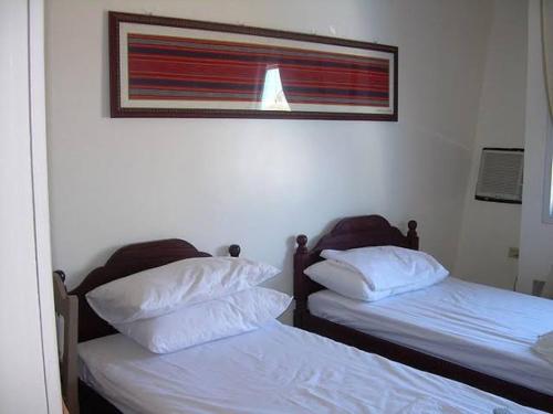 - 2 lits dans une chambre avec une photo sur le mur dans l'établissement Adtempco bed and breakfast, à Bangued