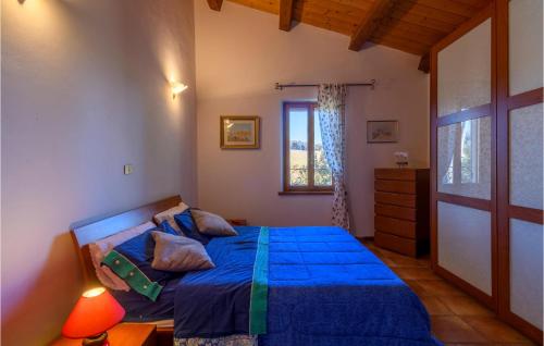 Un dormitorio con una cama azul y una ventana en Gorgeous Home In Montelabbate With Kitchen, en Montelabbate