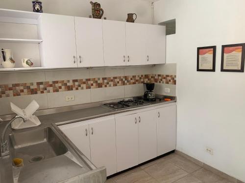 kuchnia z białymi szafkami i zlewem w obiekcie Apartamento Malí en Cali w mieście Cali