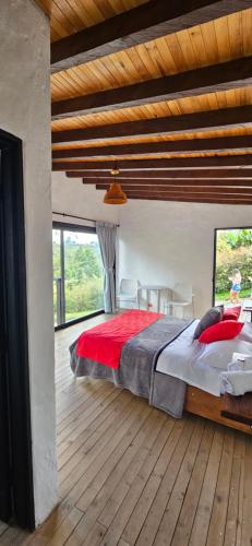 een slaapkamer met een groot bed en een houten vloer bij La escondida in Guarne