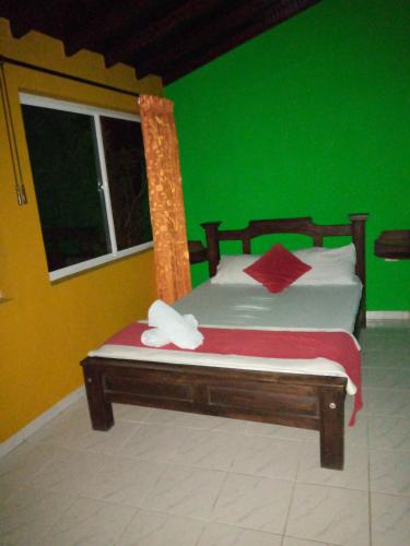 a bedroom with a bed with a green wall at Hotel La Isla in San Gil