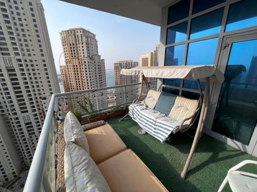 a balcony with a hammock and chairs on a building at ThePenthouse Coliving II in Dubai