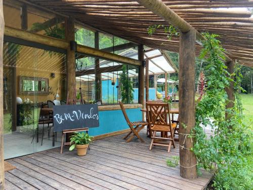 a wooden deck with chairs and a sign on it at Matha Pousada e Bistrô in Lumiar