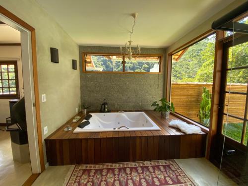 uma grande casa de banho com banheira e uma grande janela em Matha Pousada e Bistrô em Lumiar