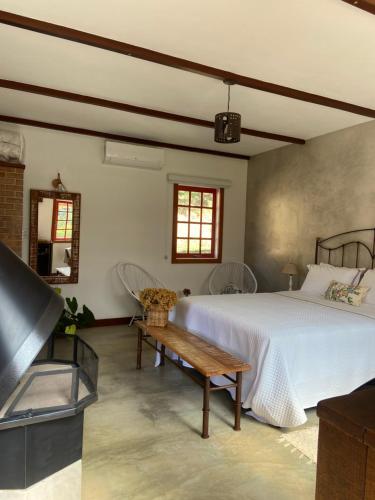 a bedroom with a large bed and a table at Matha Pousada e Bistrô in Lumiar