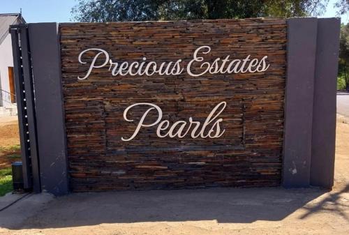 a brick wall with a sign that reads pspectorious certificates permits at Precious Estates Pearls in Zeerust