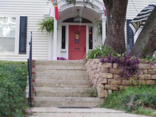- une porte rouge sur une maison blanche avec des escaliers dans l'établissement The Capitol Inn, à Tallahassee