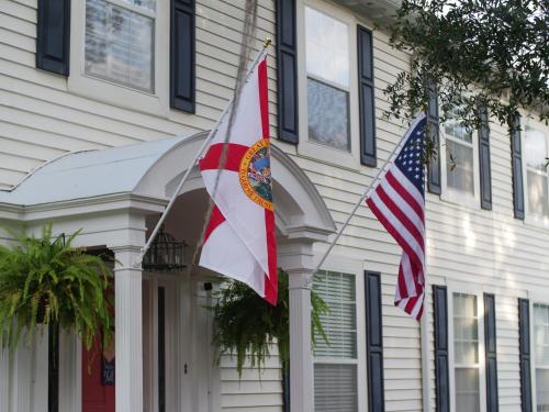 two flags are flying in front of a house at The Capitol Inn in Tallahassee