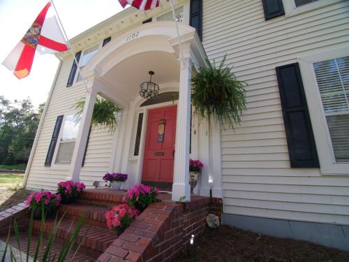 a house with a red door and flowers on the steps at The Capitol Inn in Tallahassee