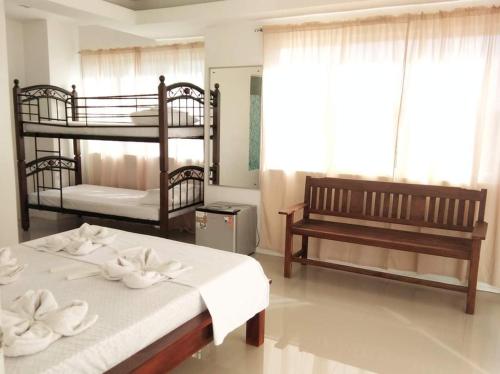 Sorrento hotel resort santa ilocos sur في Bangued: غرفة نوم بسريرين بطابقين ومقاعد
