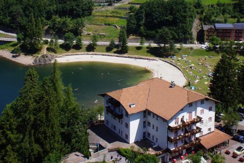 an aerial view of a building next to a lake at Hotel Pineta in Baselga di Pinè