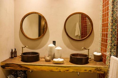 uma casa de banho com dois lavatórios e dois espelhos em Hotel Boutique Gloriagave em Tequila