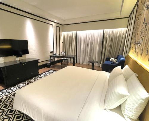 a hotel room with a white bed and a television at Bangi Resort Hotel in Bangi