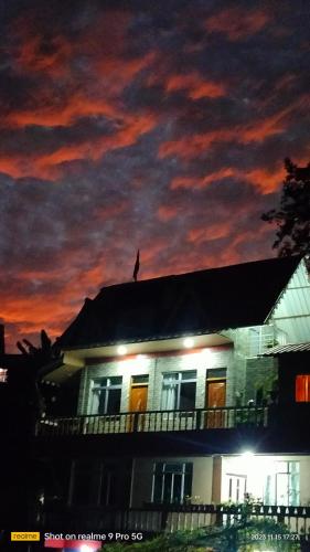 a bird sitting on top of a house at night at Holidays homestay in Mirik