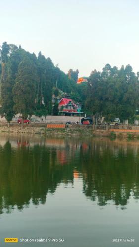 a large body of water with a house in the background at Holidays homestay in Mirik