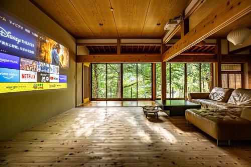 a living room with a couch and a large screen at Uwanosora Bed&BBQ&Sauna in Shizuoka