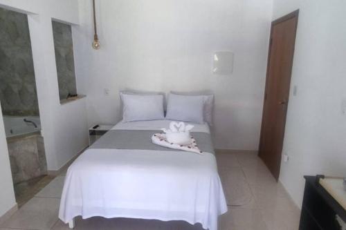 a bedroom with a white bed with a stuffed animal on it at Casa dos Villares in Águas de São Pedro