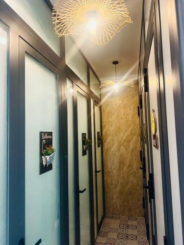a hallway with glass doors and a chandelier at Giăng's House Farmstay & Glamping in Bao Loc