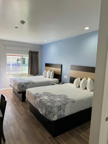 a hotel room with two beds and a window at Moonlite Inn in Redondo Beach
