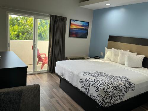 Habitación de hotel con cama y balcón en Moonlite Inn, en Redondo Beach