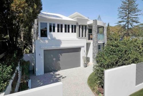 a large white house with a large garage at Currumbin Beach House - 120m to the beach in Gold Coast