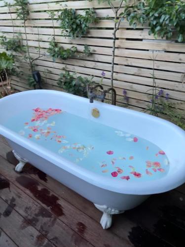 a white bath tub covered in confetti at Gardeners' Cottage in Hamilton